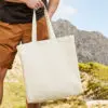 Man Outside Holding Natural 12oz Fairtrade Cotton Tote