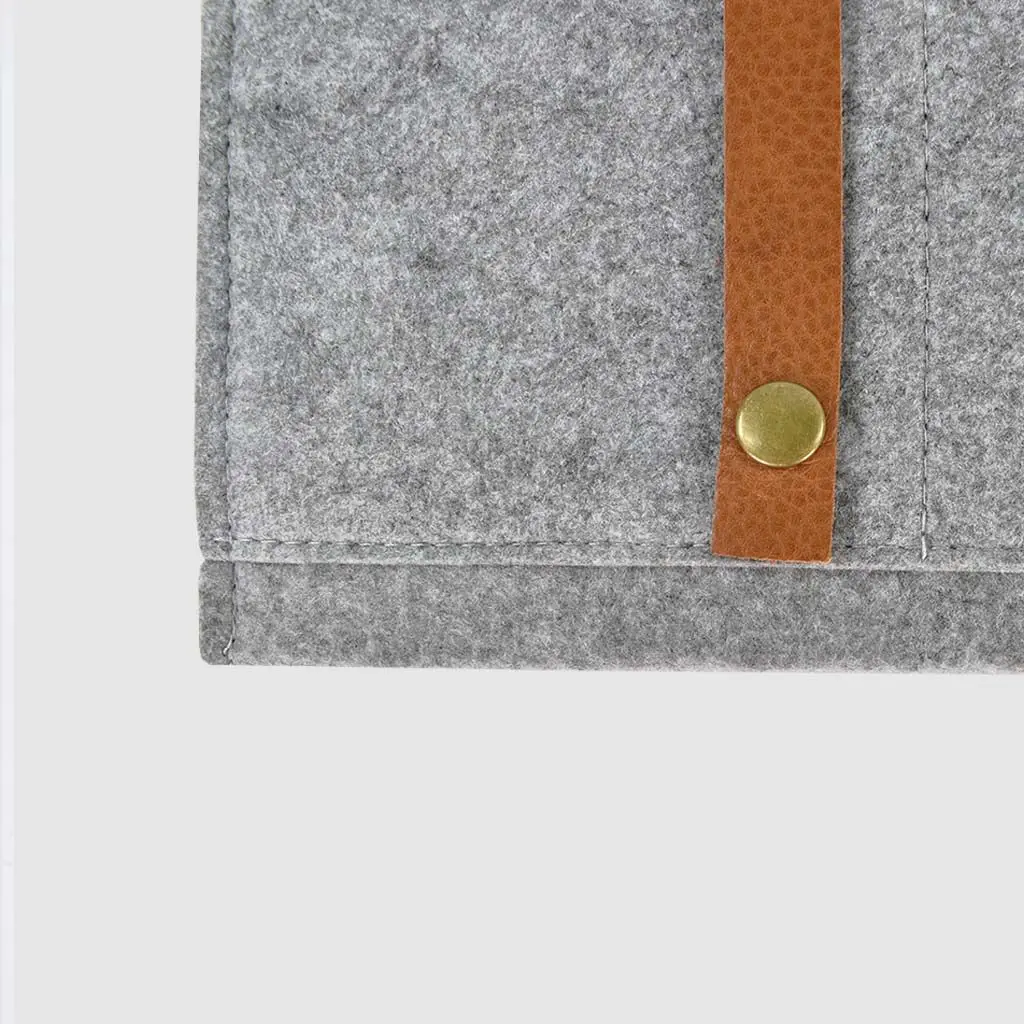 metal rivet detail on brown leather strap on felt folder