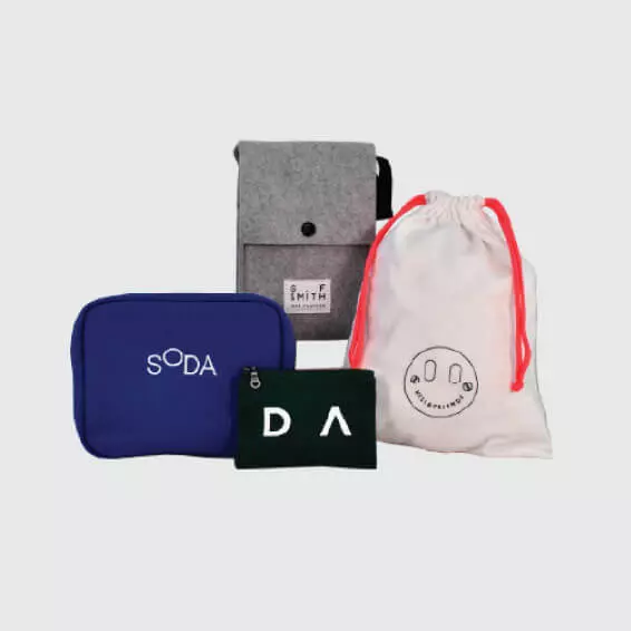 four different styles of bags laid out include a drawstring bag, zipped pouches and a popper closure on a felt bag