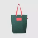 green tote bag with pink PU leather handle and badge