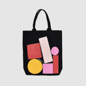 black tote bag with short handle and bright pinks and yellow print