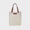 natural canvas tote bag with tan colour PU leather handles and embossed brand badge