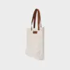 natural canvas tote bag with tan colour PU leather handles and embossed brand badge