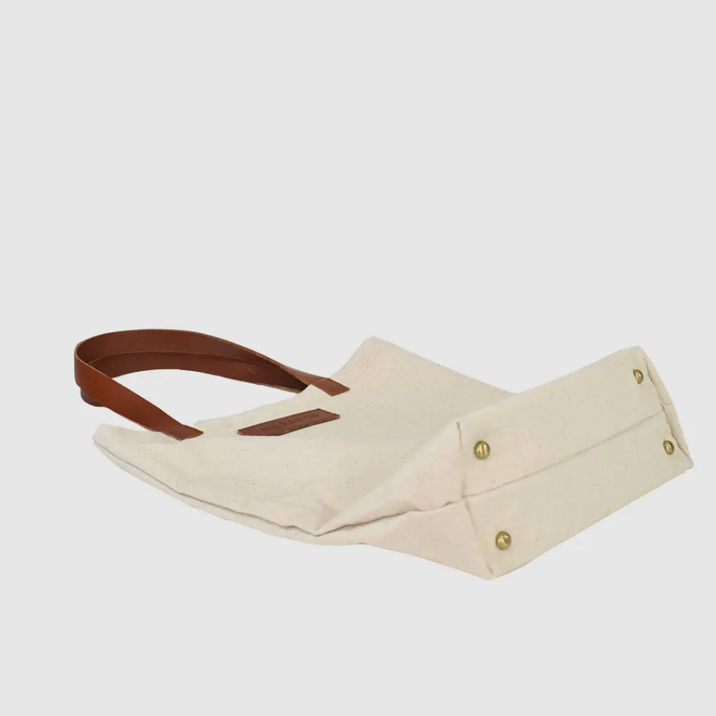 natural canvas tote bag with tan colour PU leather handles and metal stud feet
