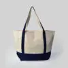 front view of cream bag with black handles and base