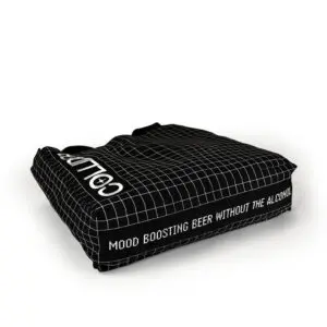 black tote bag with gusset lying flat on the ground showing the white print on the base of the bag