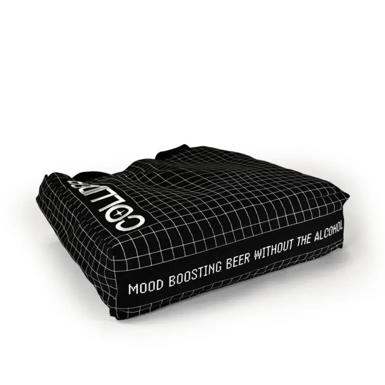 black tote bag with gusset lying flat on the ground showing the white print on the base of the bag