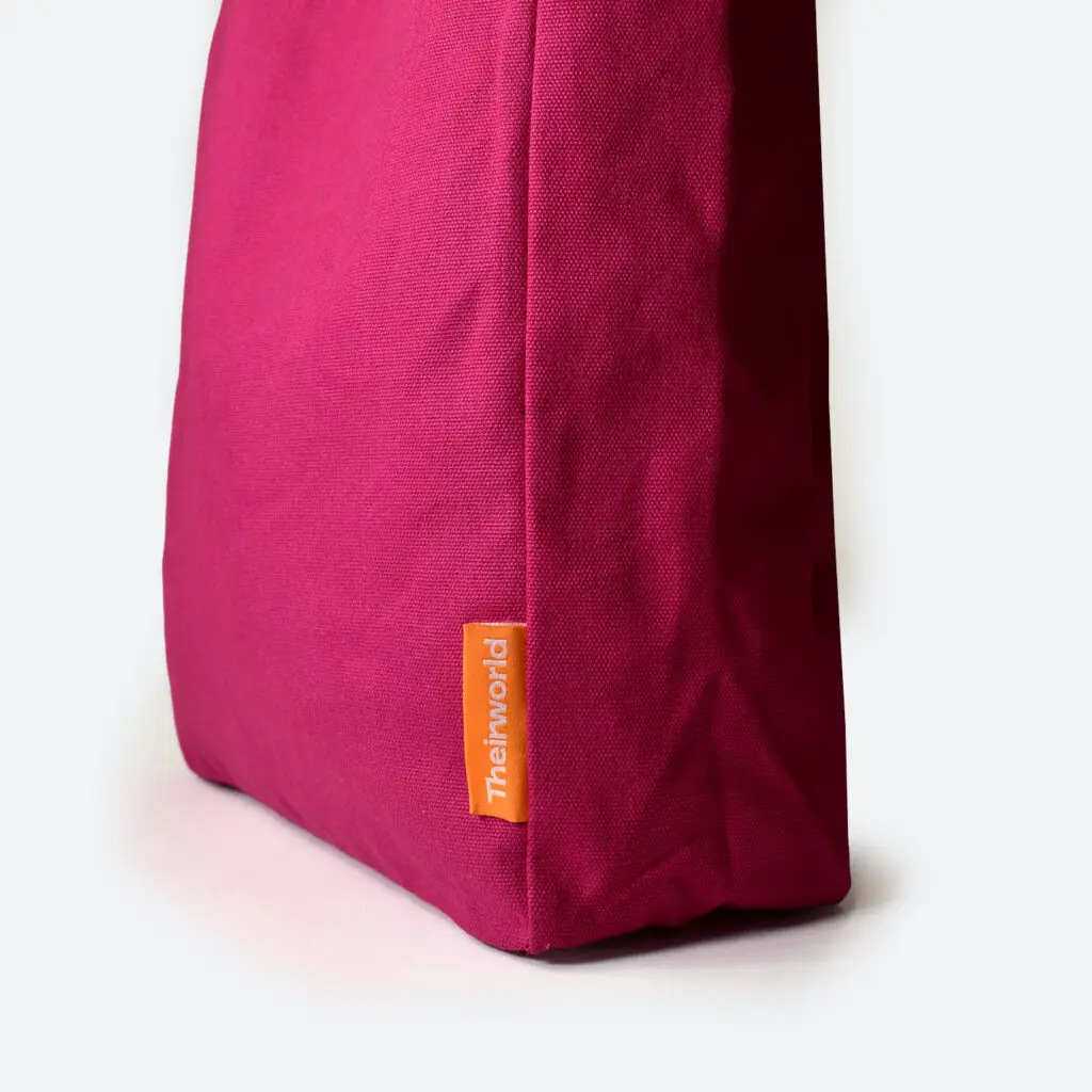 side panel of pink A4 bag with orange woven logo label