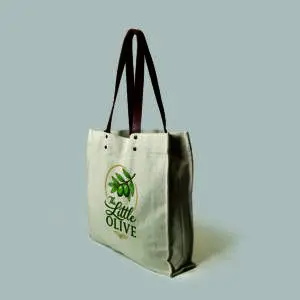 side view of natural colour canvas tote with brown leather handles