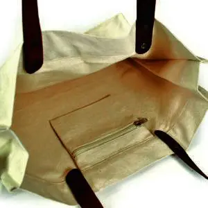 zipped pocket on inside of natural coloured bag with leather handles