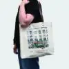 side view of tote bag with leather handles and bright print, carried by person in black top