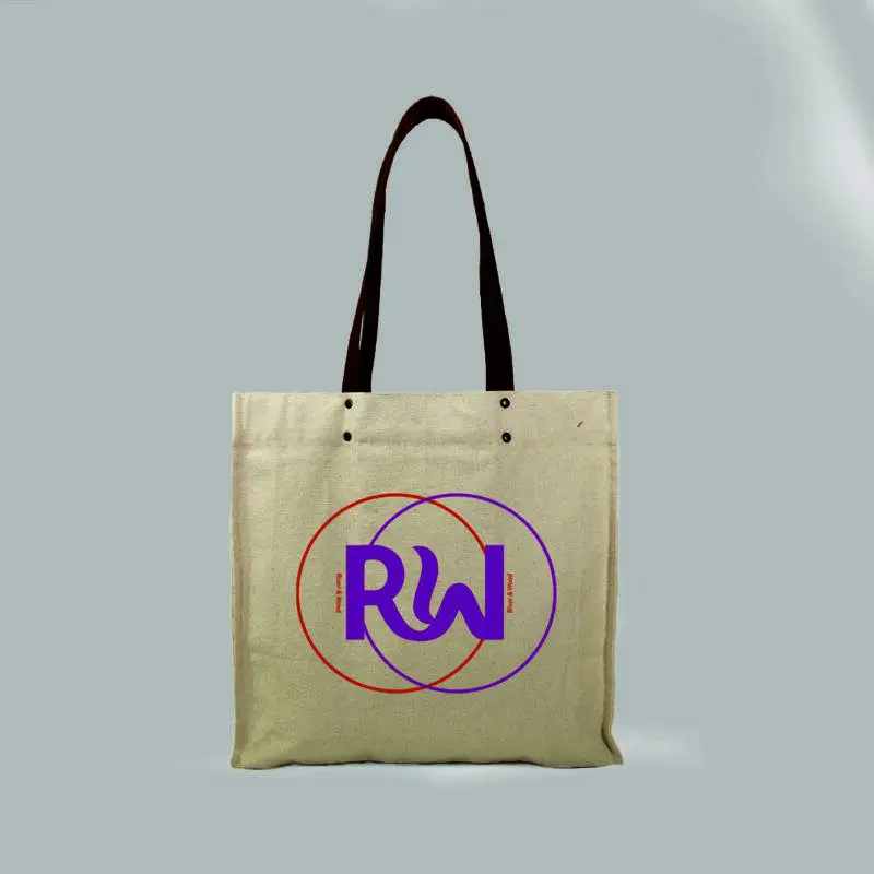 front view of a natural bag with leather handles and metal rivets. Print is orange and pink