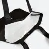 inside view of open tyvek bag that is black on outside and white on inside, taped seams and metal popper closure
