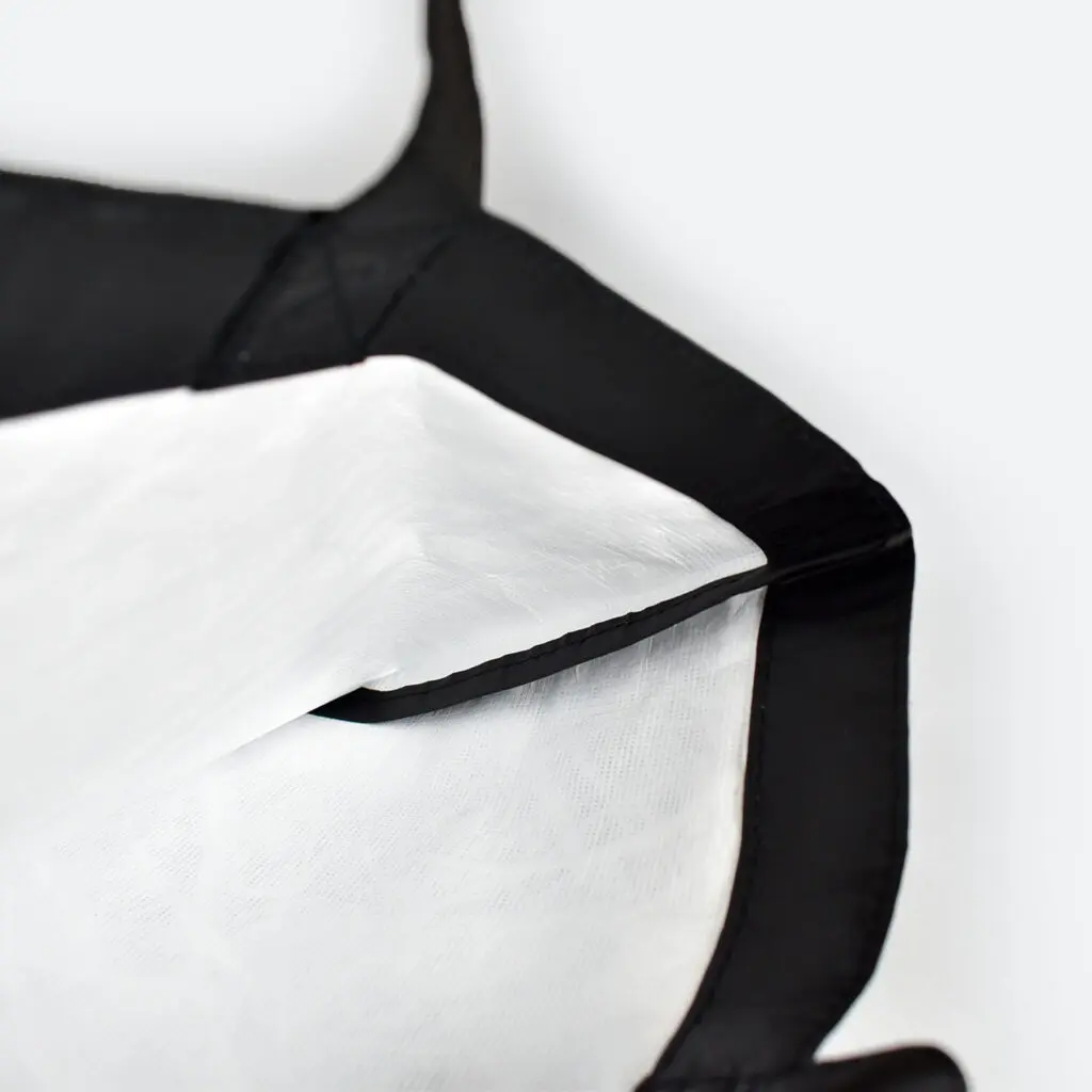 inside view of open tyvek bag that is black on outside and white on inside, taped seams and metal popper closure
