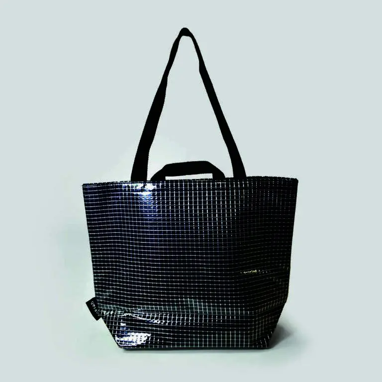 Custom bag design with short and long shoulder straps, clear panels of bag with navy felt show through and woven label in side seam