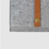 metal rivet detail on brown leather strap on felt folder
