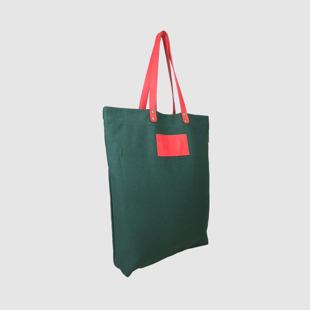 custom premium tote bag in green canvas with pink handles and badge