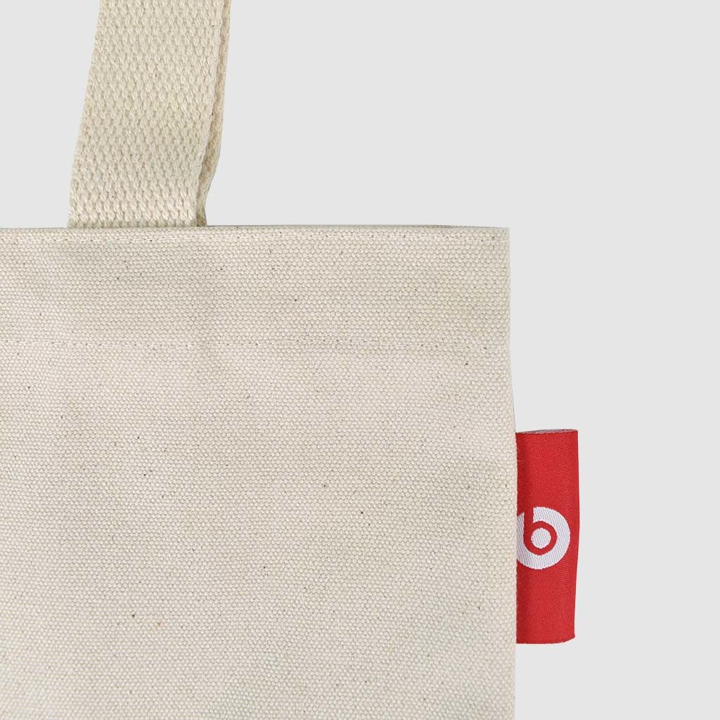 small tote bag in natural fabric with red screen print and woven logolabel