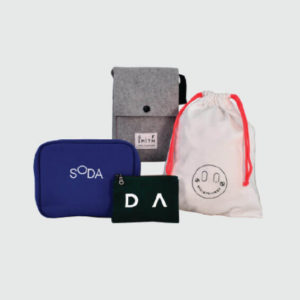 four different styles of bags laid out include a drawstring bag, zipped pouches and a popper closure on a felt bag
