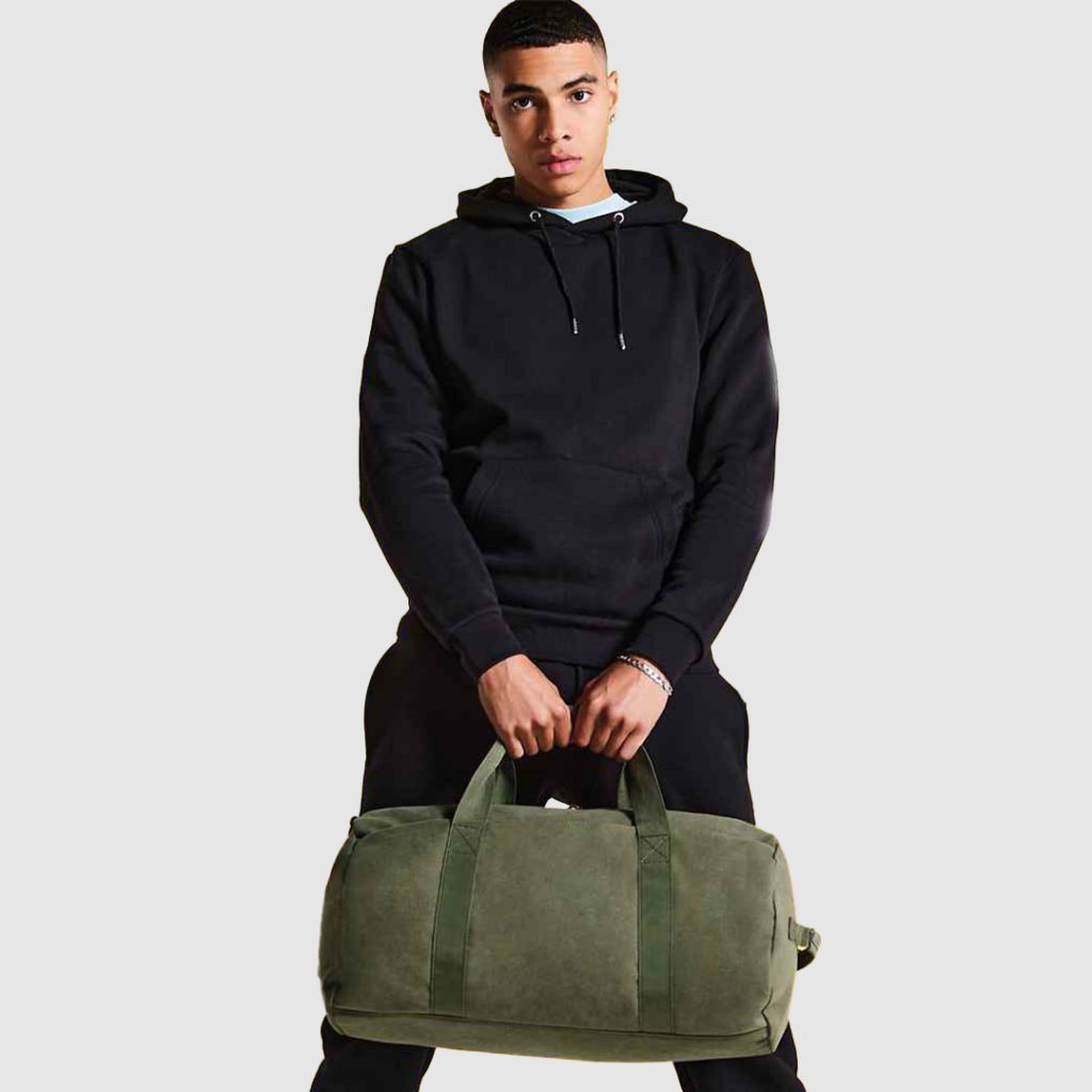 Man Holding Military Green Duffle Bag