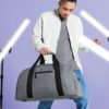 Man Holding Grey/Black handled Luggage Holdall