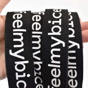hand holding four tote bag straps with white print on