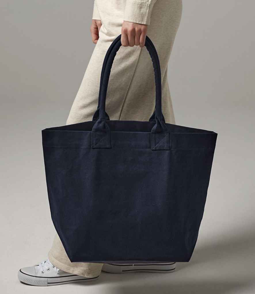 navy blue bag being held by person in cream trousers