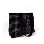 black square shape tote bag with white check print and bag straps hanging to the side
