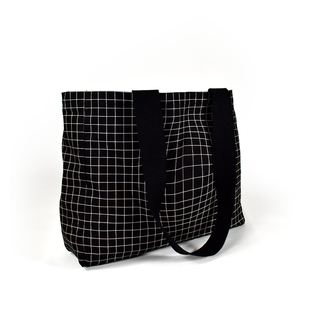 black square shape tote bag with white check print and bag straps hanging to the side