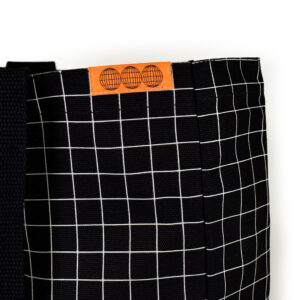 orange woven label is rectangle shape on the top seam of the black bag