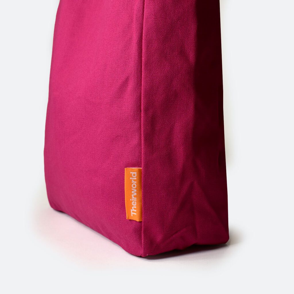 side panel of pink A4 bag with orange woven logo label