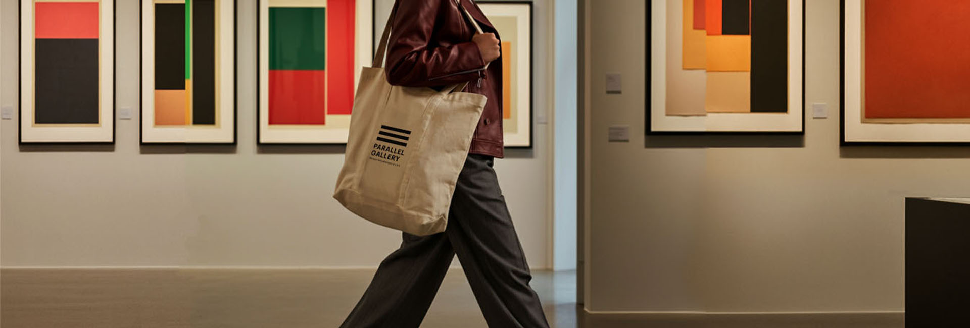 person walking with oversize tote in gallery