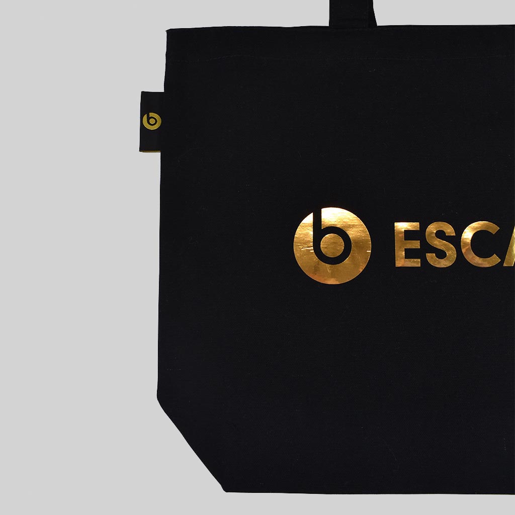 Gold mirror print on Beats by Dre on black oversize tote with woven label on outside seam also with gold logo