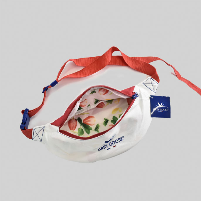 side view of belt bag with Grey Goose embroidery plus adjustable pink strap