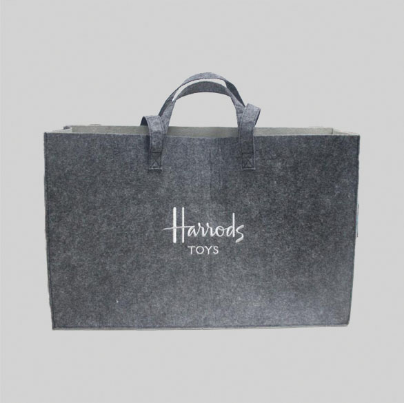 grey felt tote bag with white embroidery that says HARRODS TOYS
