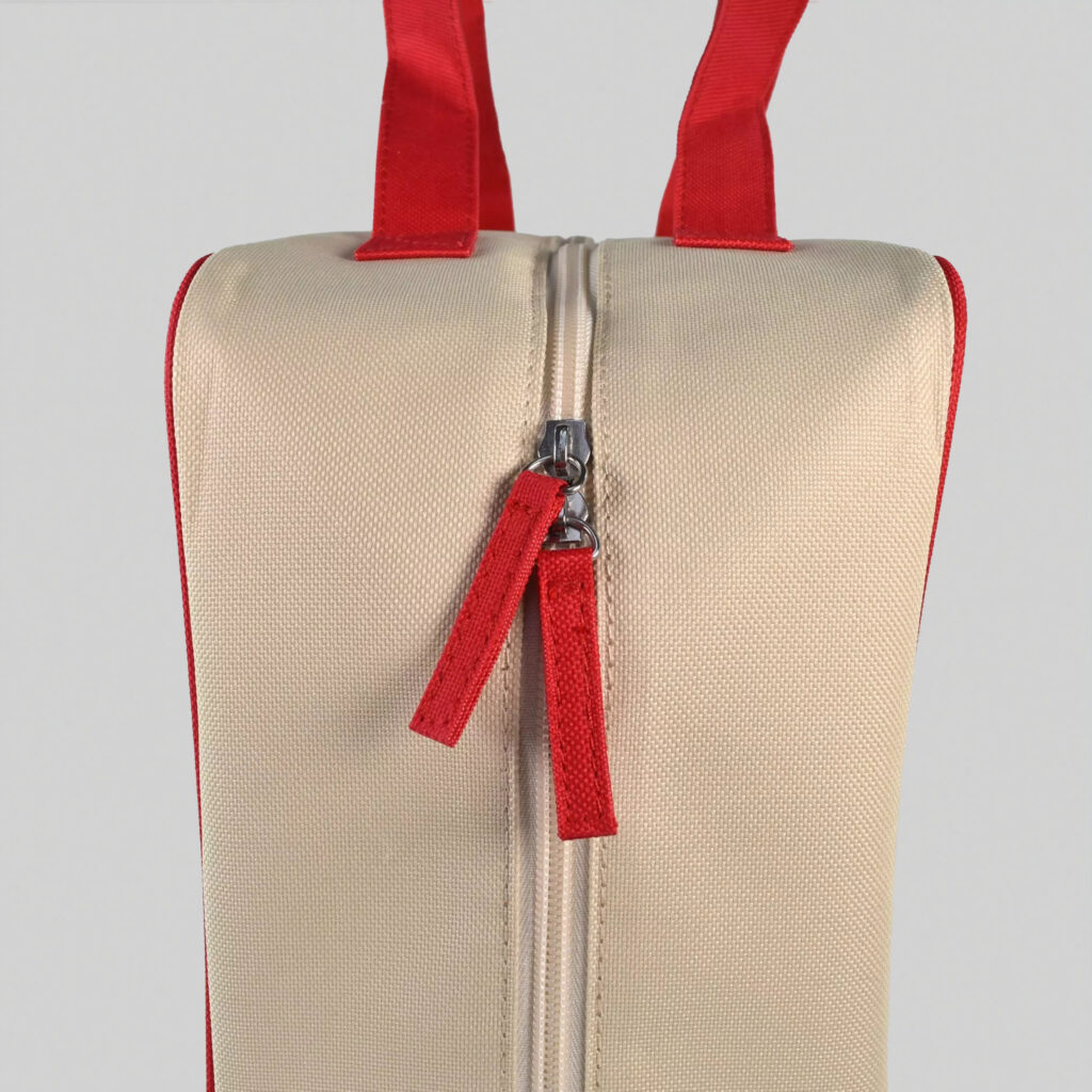 side view of zipped carry case in natural with red handles and sip pulls